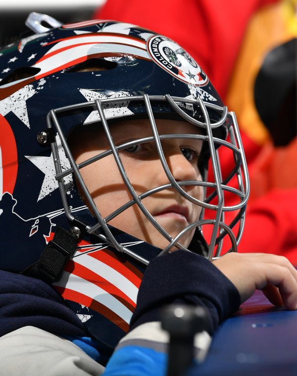 Boy wearing Columbus Blue Jacket goalie helmet