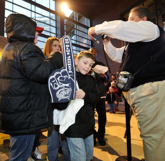 Boy holding up foam finger while entering Columbus Blue Jacket arena