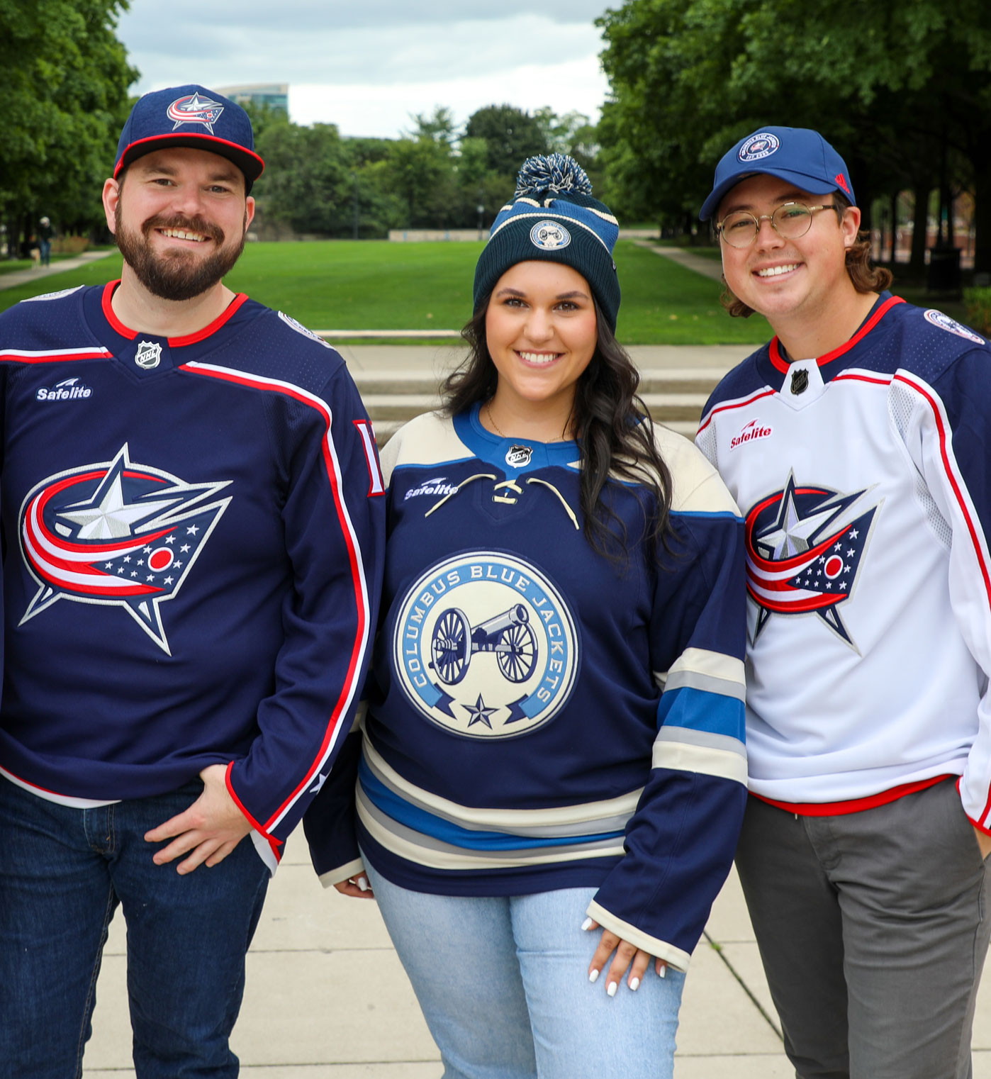 Three friends wearing team gear at Columbus Blue Jacket store