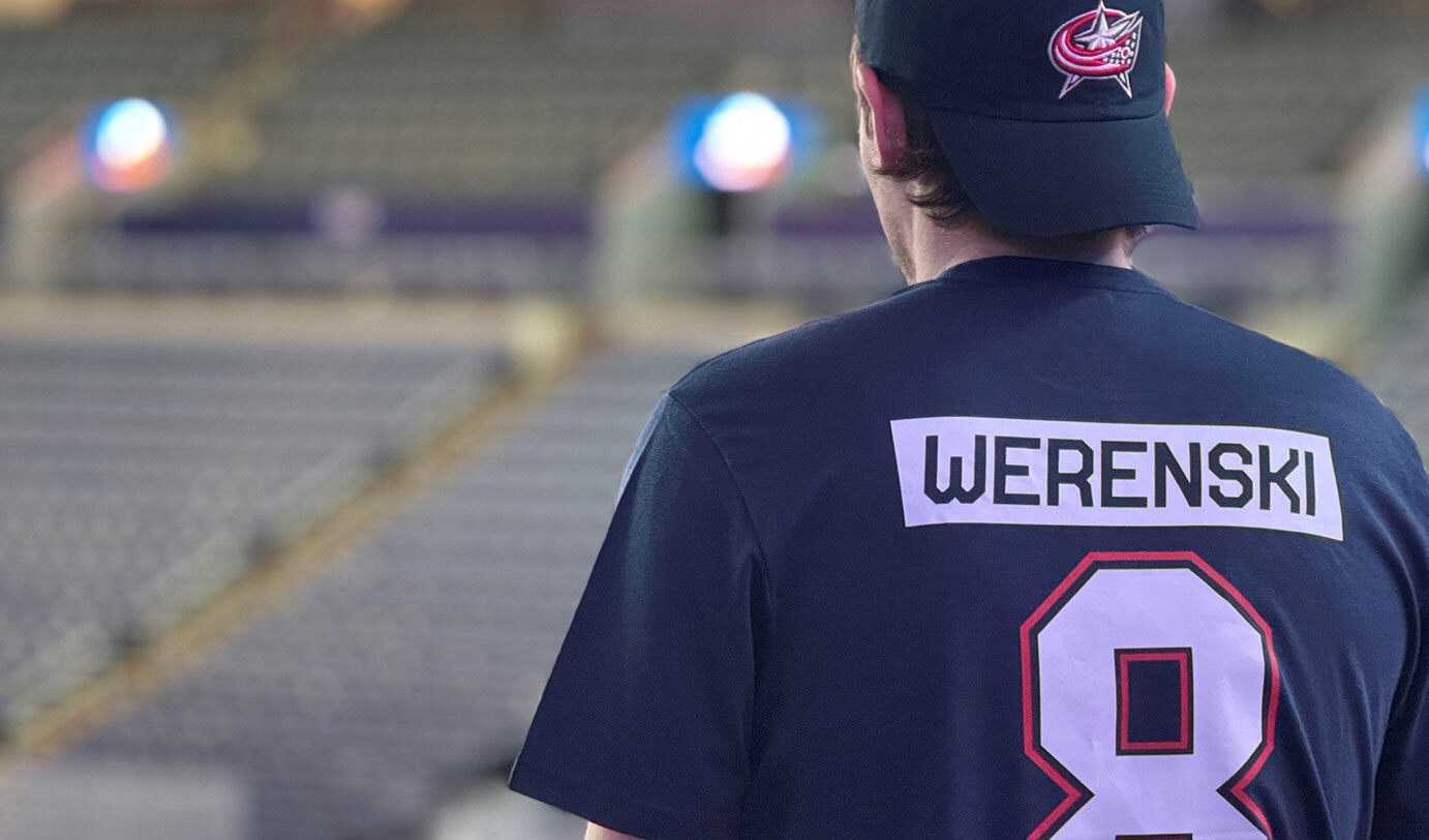 Man wearing Columbus Blue Jacket hat and t-shirt in arena